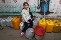 Trẻ em Palestine chờ lấy nước bên trong một trại di tản ở Gaza, ngày 6/4/2025. (Ảnh: Xinhua)