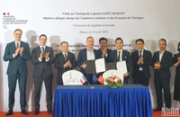 Bộ trưởng đặc trách Ngoại thương và người Pháp ở nước ngoài Laurent Saint-Martin (hàng sau, thứ 2 từ trái sang) và các đại biểu chứng kiến đại diện các doanh nghiệp hai nước ký kết thỏa thuận hợp tác. (Ảnh: TRUNG HƯNG)