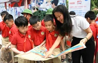 Học sinh Trường tiểu học Tràng An tham quan và trải nghiệm triển lãm.