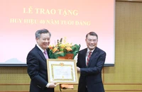 Đồng chí Lê Minh Hưng trao tặng Huy hiệu 40 năm tuổi đảng và chúc mừng đồng chí Nguyễn Quang Dương.