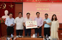 Đại diện Báo Nhân Dân và Công ty cổ phần Văn hóa học và học Việt Nam trao tặng tiền ủng hộ cho huyện Nho Quan (Ninh Bình).