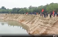 Người dân xã Đồng Văn, huyện Thanh Chương tập trung bên bờ sông Lam, dựng lán, đánh trống… để phản đối hoạt động khai thác cát, sỏi của Công ty cổ phần Khai thác cát, sạn và Vận tải Thanh Chương. (Ảnh cắt từ video clip)