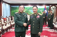 Thượng tướng Hoàng Xuân Chiến chào Bộ trưởng Quốc phòng Lào Khamlieng Outhakaysone. (Ảnh: TRỊNH DŨNG)