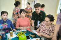 Cựu chiến binh Hoàng Văn Đạt (áo bộ đội) tặng quà các gia đình chính sách phường Đức Giang.