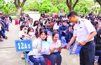 Báo cáo viên tuyên truyền, phát tờ rơi về thu hút nguồn nhân lực tại Trường THPT Hùng Vương, thành phố Quy Nhơn. (Ảnh THANH SANG)