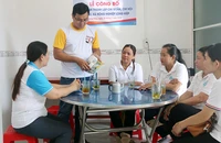 Giám đốc Hợp tác xã nông nghiệp Long Hiệp Trầm Minh Thuần (đứng) trao đổi kinh nghiệm với các cán bộ xã Lưu Nghiệp Anh, huyện Trà Cú, tỉnh Trà Vinh.
