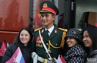 Bà con người Việt Nam tại Nga vui vẻ chụp ảnh lưu niệm với quân nhân Việt Nam tham gia hợp luyện chuẩn bị cho Lễ duyệt binh tại Quảng trường Đỏ.
