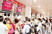 Người dân làm thủ tục tại Sân bay Tân Sơn Nhất. (Ảnh THẾ ANH)