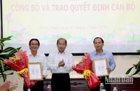 Phó Chủ tịch Ủy ban nhân dân tỉnh Đồng Tháp Đoàn Tấn Bửu trao quyết định cho ông Trần Tấn Lực (bìa phải) và ông Nguyễn Duy Trung. (Ảnh: NGUYỆT ÁNH)