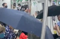 Hành khách phải che ô do nước từ điều hòa tàu chảy xuống sàn chiều 19/5. (Ảnh: cắt từ clip)