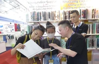 Khách tham quan, tìm hiểu sản phẩm dệt may tại một gian hàng tại triển lãm trong sáng 5/4.