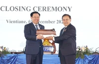 Chủ tịch Quốc hội Vương Đình Huệ nhận búa đảm nhận chức Chủ tịch Hội nghị cấp cao Quốc hội ba nước CLV lần thứ hai từ Chủ tịch Quốc hội nước Lào Saysomphone Phomvihane. (Ảnh: TTXVN)