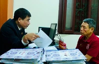 Cán bộ Tòa án nhân dân huyện Lý Nhân, tỉnh Hà Nam giải thích quy định pháp luật cho người dân. (Ảnh HẢI ĐĂNG)