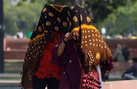 Người dân di chuyển dưới thời tiết nắng nóng tại New Delhi, Ấn Độ, ngày 15/5/2023. (Ảnh: Reuters)
