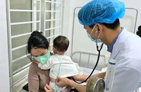 Bác sĩ Khoa Bệnh Nhiệt đới (Bệnh viện Sản-Nhi Nghệ An) khám cho bệnh nhi mắc sởi.
