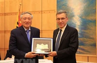 Chánh án Tòa án Nhân dân Tối cao Nguyễn Hòa Bình (trái) tặng quà lưu niệm cho ông Christian Coquoz, Chánh án Tòa án bang Geneva. (Ảnh: TTXVN)
