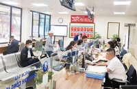 Người dân đến làm thủ tục tại bộ phận “một cửa” Ủy ban nhân dân quận Đống Đa. (Ảnh: QUỐC TOẢN)