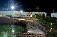 Lực lượng chức năng và người dân tìm kiếm tại khu vực hố sụt trong đêm 26/7. (Ảnh: TUẤN SƠN).