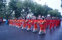 Phụ nữ Hà Nội trong trang phục áo dài diễu hành bên hồ Hoàn Kiếm.