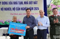 Chủ tịch Ủy ban nhân dân tỉnh Thái Bình Nguyễn Khắc Thận trao biểu trưng hỗ trợ 100 triệu đồng xây nhà mới cho bà Nguyễn Thị Xíu, là hộ nghèo tại xã Tự Tân, huyện Vũ Thư.