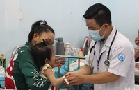 Bác sĩ Bệnh viện Nhi đồng 1 đang khám cho trẻ mắc tay chân miệng (Ảnh: Thế Anh)