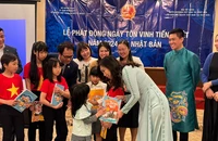Thứ trưởng Lê Thị Thu Hằng trao quà cho các em học sinh tại Lễ phát động. (Ảnh: Bộ Ngoại giao)
