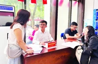 Cán bộ Trung tâm Phục vụ hành chính công-Chi nhánh số 7 hướng dẫn người dân hoàn thiện hồ sơ trước khi vào cửa tiếp nhận.