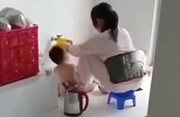 Hình ảnh bảo mẫu đổ thức ăn vào miệng trẻ lan truyền trên mạng xã hội. (Ảnh: Cắt ra từ clip)