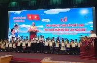 Trao quyết định và tặng quà các cháu được nhận đỡ đầu. (Ảnh: NGỌC HÒA)