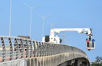 Xe chuyên dụng đưa các kỹ thuật viên xuống dưới dầm cầu Khuê Ðông.