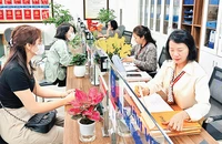 Người dân thực hiện giải quyết thủ tục hành chính tại Bộ phận một cửa quận Ðống Ða. (Ảnh Nguyên Bảo)
