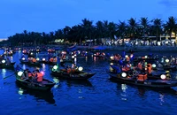 Du khách đi thuyền trên sông Hoài tham quan phố cổ Hội An vào ban đêm. (Ảnh ÐĂNG KHOA)