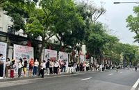 Sáng 30/4, hàng dài người xếp hàng nhận phụ san 30/4 của Báo Nhân Dân. (Ảnh: QUỲNH TRANG)