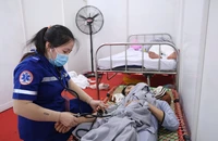 Nhân viên y tế chăm sóc người dân bị say nắng. (Ảnh: THẾ ANH)