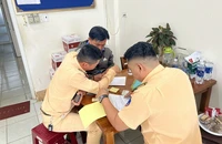 Lực lượng cảnh sát giao thông lập biên bản vi phạm đối với tài xế Thông.