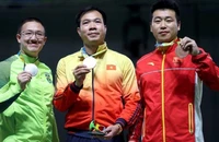 Hoàng Xuân Vinh (ở giữa) trên bục nhận huy chương. (Ảnh: Reuters)