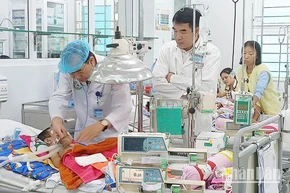 Bác sĩ Phạm Văn Dũng (bên trái) thăm khám cho bệnh nhân.