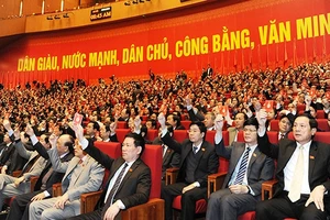 Các đại biểu biểu quyết thông qua Nghị quyết Đại hội lần thứ XII của Đảng. Ảnh: TRẦN HẢI