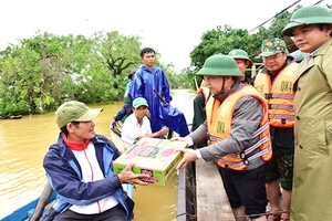 Lãnh đạo tỉnh Thừa Thiên Huế thăm hỏi, động viên và trao thực phẩm hỗ trợ người dân gặp khó khăn ở vùng ngập lụt ven sông Bồ. Ảnh: VĂN THẮNG