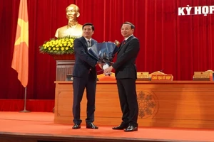 Đồng chí Nguyễn Xuân Ký, Bí thư Tỉnh ủy Quảng Ninh tặng hoa chúc mừng đồng chí Nguyễn Tường Văn (bên trái), Chủ tịch UBND tỉnh Quảng Ninh nhiệm kỳ 2016-2021.