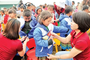 Cán bộ, đoàn viên thanh niên Công ty Du lịch Vietravel tặng áo ấm cho học sinh điểm Trường tiểu học Tọt Còn, xã Cao Thượng, huyện Ba Bể (Bắc Kạn).Ảnh: Nguyễn Ðăng