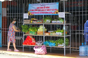 Người dân hẻm 17, đường Gò Dầu (phường Tân Quý, quận Tân Phú, TP Hồ Chí Minh) đi chợ tại "Gian hàng 0 đồng sẻ chia cùng khu cách ly". Ảnh: HUẾ XUÂN