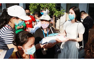 Người dân có hoàn cảnh khó khăn nhận quà hỗ trợ từ chủ quán bún ngan ở Hà Nội. Ảnh: LÊ PHÚ