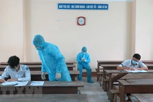 Hai thí sinh trong khu vực phong toả ở Phú Yên được bố trí phòng thi riêng, cán bộ coi thi mặc đồ bảo hộ. Ảnh: XUÂN TRIỆU/TTXVN