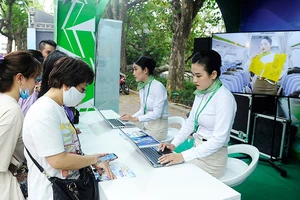 Khách hàng đặt mua vé máy bay trên điện thoại di động tại lễ hội du lịch và văn hóa ẩm thực Hà Nội năm 2021 - ảnh chụp trước khi dịch Covid-19 bùng phát lần thứ tư. (Ảnh: ANH SƠN)