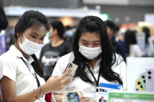 Khách hàng dùng thử điện thoại tại một cuộc Hội chợ Điện thoại di động ở thủ đô Bangkok, Thái Lan. (Ảnh: Bưu điện Bangkok)