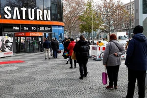 Người mua sắm xếp hàng trước cửa hàng điện tử Saturn trên đại lộ Tauentzienstrasse ở Berlin, Đức, ngày 14/12/2020. (Ảnh: Reuters)