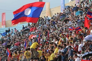 Cổ động viên trên khán đài nhiệt tình cổ vũ cho đội U23 Lào. (Ảnh: TTXVN)