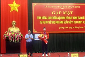 Phó Bí thư Thường trực Tỉnh ủy Quảng Bình Trần Hải Châu trao thường và tặng hoa cho Nguyễn Huy Hoàng.
