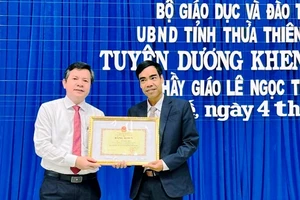 Giám đốc Sở Giáo dục và Đào tạo trao Bằng khen của Bộ Giáo dục và Đào tạo và UBND tỉnh cho thầy giáo Lê Ngọc Thùy (bên phải).